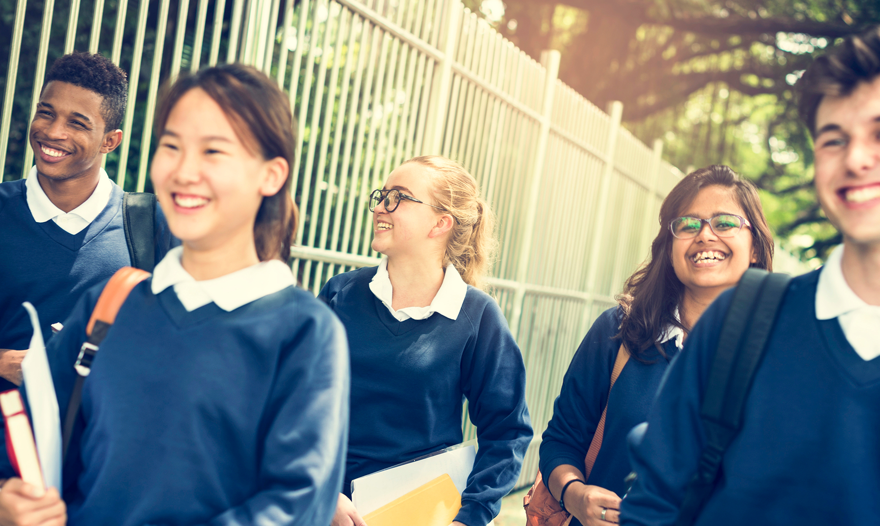 A group of students in school uniforms walking together, engaged in conversation and enjoying their time.