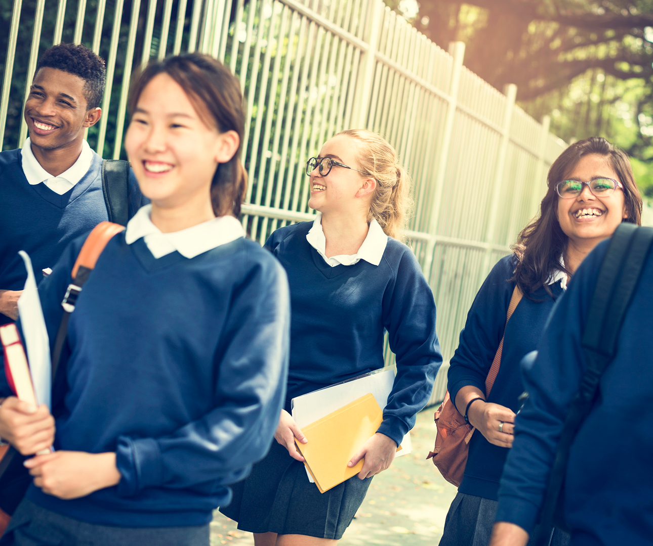 A diverse group of students in school uniforms walking together, sharing laughter and camaraderie on their way to school.