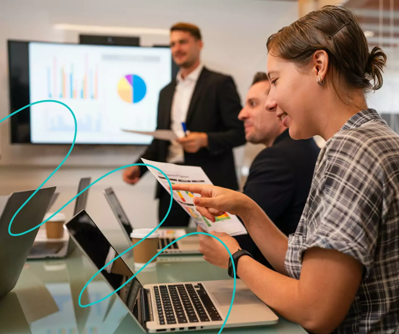 People sat around the table with lap tops looking at stats on screens.